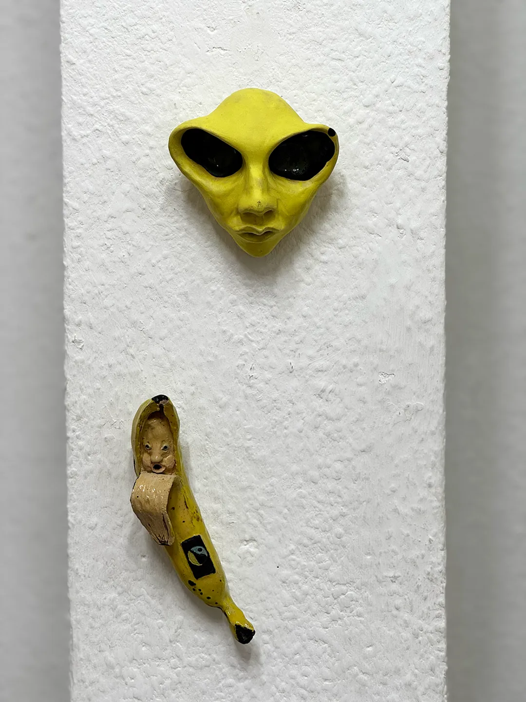 keraaminen keltainen "alien" ja keraaminen reilunkaupan banaani jolla kasvot